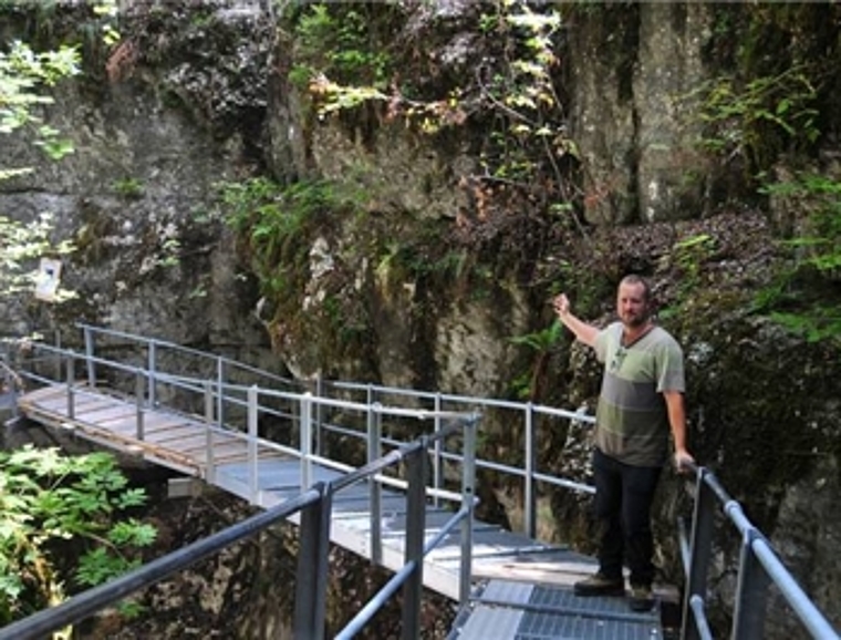 Revierförster Jakob Römer zeigt den rund 20 Meter langen Abschnitt, der mit einer Galerie vor weiterem Steinschlag geschützt werden soll. (Bild: ZVG)