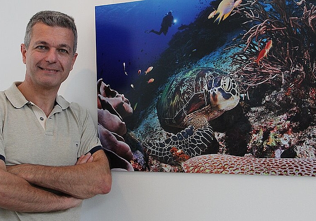 Der Unterwasserfotograf Piero Ambrosone neben seiner eindrücklichen Aufnahme einer Meeresschildkröte. (Bild: mim)