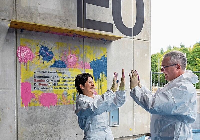 Die beiden Regierungsräte Sandra Kolly und Remo Ankli beglückwünschen sich gegenseitig zu ihrem farbigen Einweihungswerk an der Kanti-Fassade. (Bild: Patrick Lüthy)
