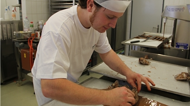 Antoine Jacot platziert die Hühnerfiguren auf ein mit Schokolade bestrichenes Blech und stellt diese zum Kühlen. mim)
