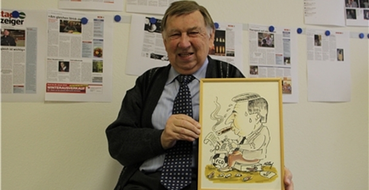 Der 75-jährige Sportjournalist Walter Ernst mit seiner Karikatur. Er ist heute als freier Journalist sportlich im Einsatz. mim)
