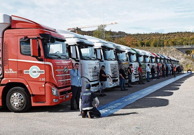 Die Lastwagen reihten sich vor dem blauen Band auf, das sie dann um 15.06 Uhr überquerten und so gemeinsam den fünfmillionsten Kilometer fuhren. (Bilder: FB)